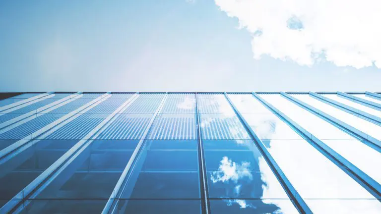 Modern Office building from low angle showing the sky and reflected sky in blue tones reflective windows